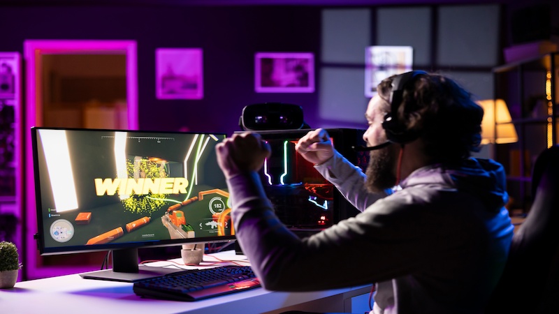 Gamer celebrating victory on playing game site playbattlesquare with immersive gameplay on a high-end gaming setup